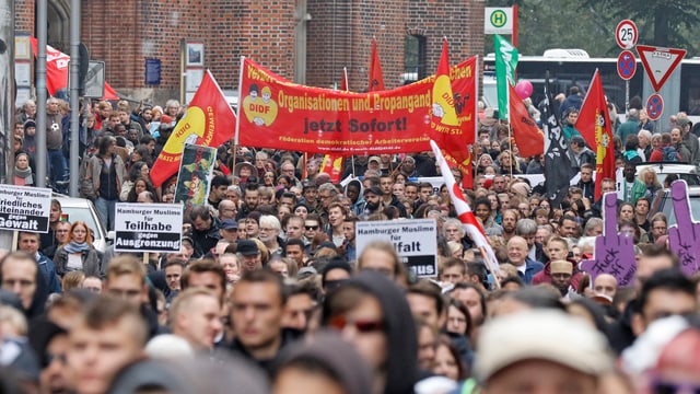 Eine Menschenmenge, die Plakate hochhält Eine Menschenmenge, die Plakate hochhält