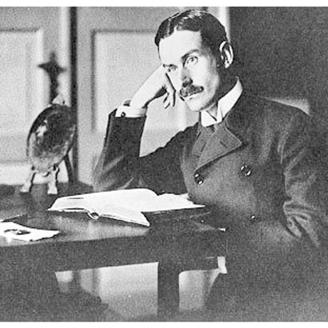 Thomas Mann sitzt über einem Buch am Schreibtisch. Thomas Mann sitzt über einem Buch am Schreibtisch.