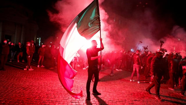 Protestierende mit Italien-Fahnen im Schein von roten Signalfackeln. Protestierende mit Italien-Fahnen im Schein von roten Signalfackeln.