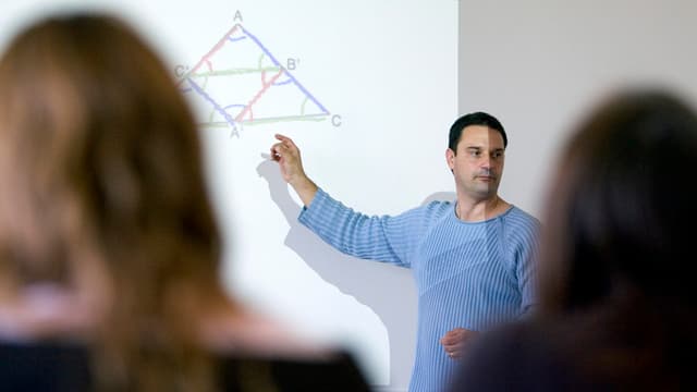 Lehrer vor einer Projektion an der Wand. Lehrer vor einer Projektion an der Wand.