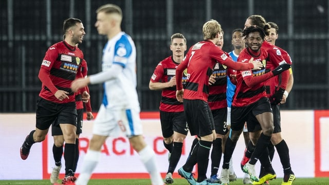 Fussballspieler mit rot-schwazrem Dress auf dem Fussballplatz. Fussballspieler mit rot-schwazrem Dress auf dem Fussballplatz.