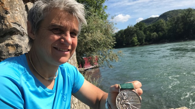 Sabine Eichenberger zeigt eine Medaille, im Hintergrund die Aare Sabine Eichenberger zeigt eine Medaille, im Hintergrund die Aare