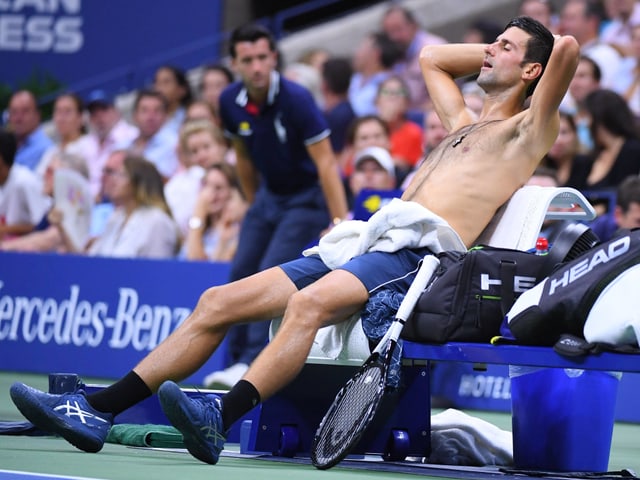 Novak Djokovic sitzt erschöpft auf einem Stuhl. Novak Djokovic sitzt erschöpft auf einem Stuhl.
