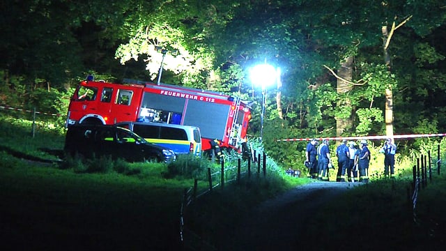 Feuerwehrauto in einem Waldstück in der Nacht. Flutlichter brennen. Feuerwehrauto in einem Waldstück in der Nacht. Flutlichter brennen.