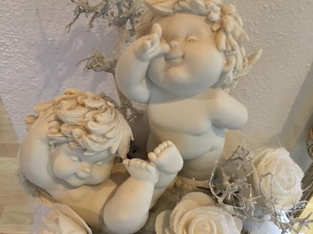 Zwei lustige Tonengel auf weissem Felm mit weissen Porzellanrosen und Sternen