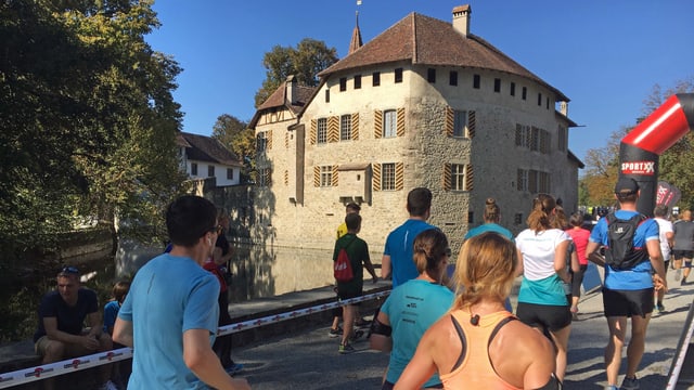 Läuferinnen und Läufer laufen auf das Schloss Hallwyl zu Läuferinnen und Läufer laufen auf das Schloss Hallwyl zu