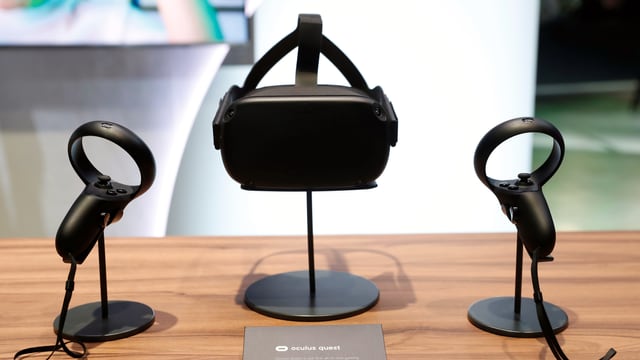 Eine Oculus-Quest-Brille steht zwischen zwei Oculus-Quest-Controllern. Eine Oculus-Quest-Brille steht zwischen zwei Oculus-Quest-Controllern.