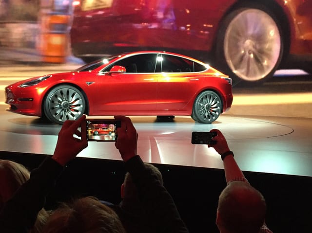 Zuschauer fotograhieren einen Tesla. Zuschauer fotograhieren einen Tesla.