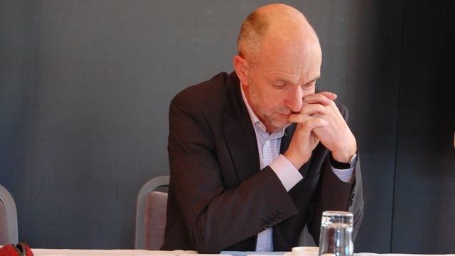 Mann schaut nachdenklich in die Akten. Mann schaut nachdenklich in die Akten.