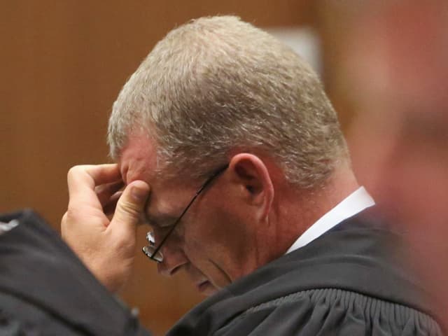 Mann mit Brille stützt seinen Kopf auf die Hand