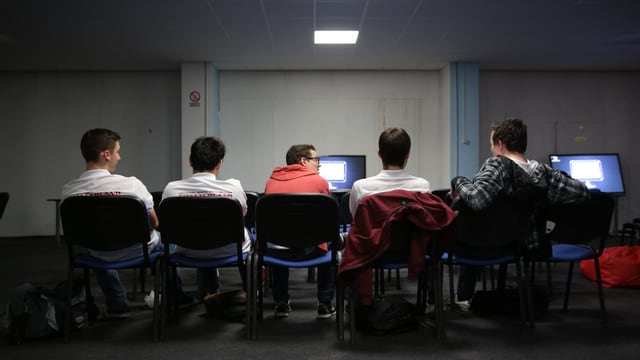 Die fünf Schweizer sitzen aufgereiht in einem kahlen Saal. Die fünf Schweizer sitzen aufgereiht in einem kahlen Saal.