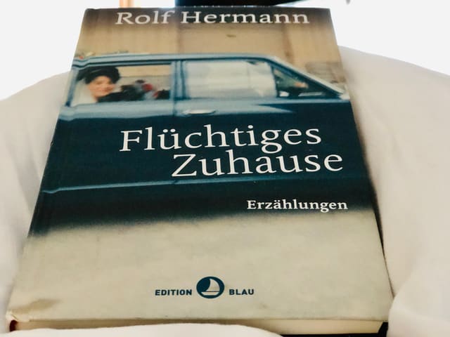 Das Buch «Flüchtiges Zuhause» von Rolf Hermann liegt auf einer weissen Bettdecke Das Buch «Flüchtiges Zuhause» von Rolf Hermann liegt auf einer weissen Bettdecke