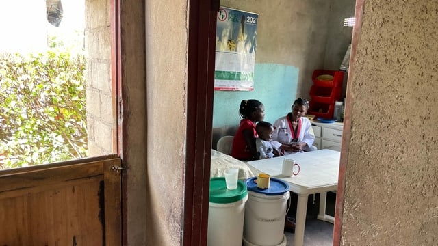 Blick durch Tür in Küche, wo zwei Mädchen und ein Baby am Tisch sitzen Blick durch Tür in Küche, wo zwei Mädchen und ein Baby am Tisch sitzen