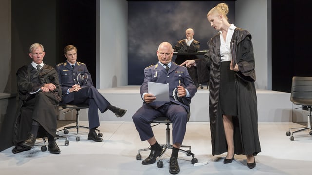 Theaterszene: Menschen in Talar und Uniformen auf einer Bühne. Theaterszene: Menschen in Talar und Uniformen auf einer Bühne.