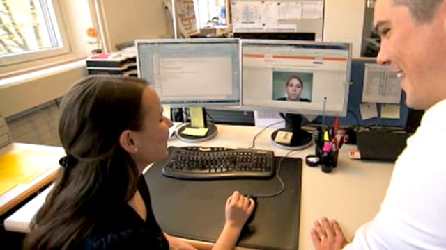 Frau und Mann schauen auf Bildschirm und unterhalten sich dabei. Frau und Mann schauen auf Bildschirm und unterhalten sich dabei.