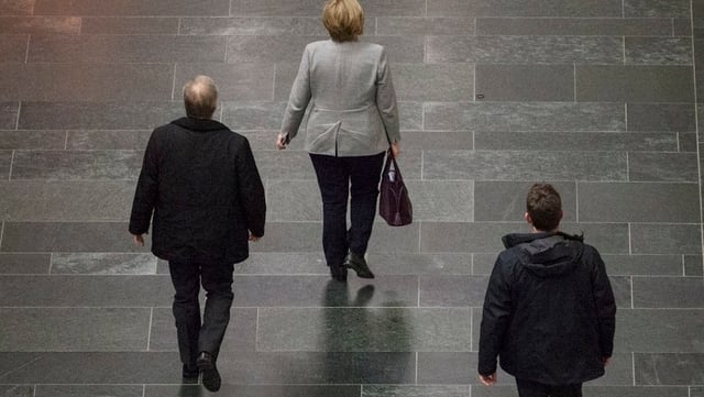Die deutsche Bundeskanzlerin läuft einen Gang entlang. Die deutsche Bundeskanzlerin läuft einen Gang entlang.