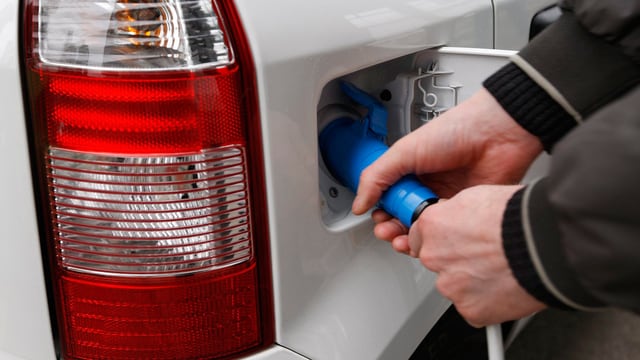 Zwei Hände beim Betanken eines weissen Autos. Zwei Hände beim Betanken eines weissen Autos.