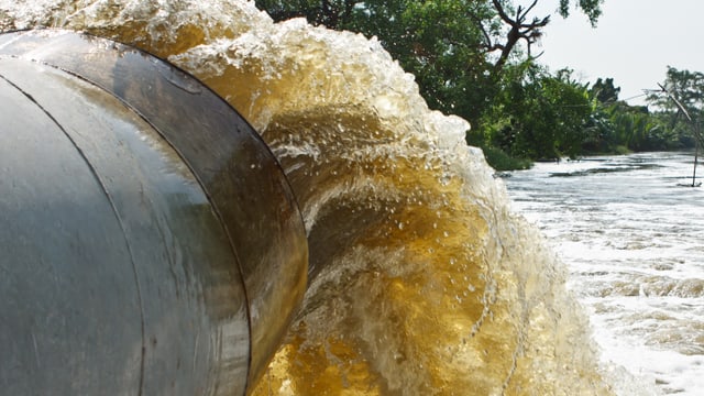 Wasser aus Rohr fliesst in Fluss. Wasser aus Rohr fliesst in Fluss.