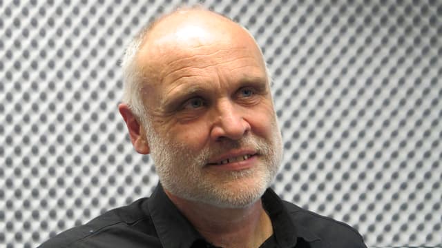 Martin Haug trägt kurzes graues Haar. Er ist im Radiostudio. Martin Haug trägt kurzes graues Haar. Er ist im Radiostudio.