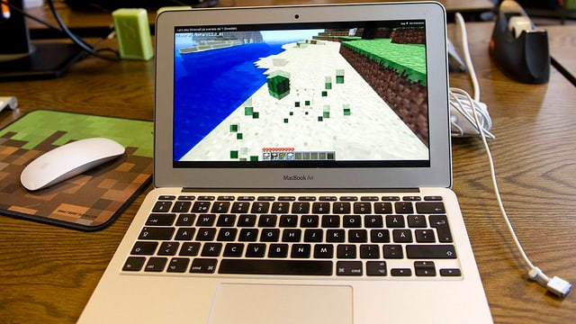 Notebook, auf dem Bildschirm ist die Minecraft-Klötzchenwelt erkennbar. Notebook, auf dem Bildschirm ist die Minecraft-Klötzchenwelt erkennbar.