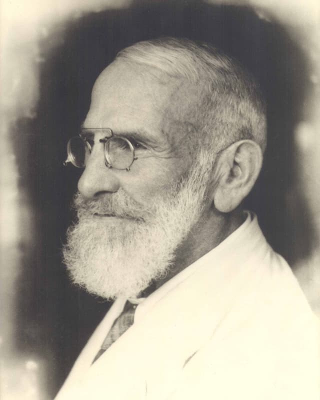 Schwarz-weiss Foto von Maximilian Bircher-Benner mit Bart und Brille im weissen Anzug. Schwarz-weiss Foto von Maximilian Bircher-Benner mit Bart und Brille im weissen Anzug.