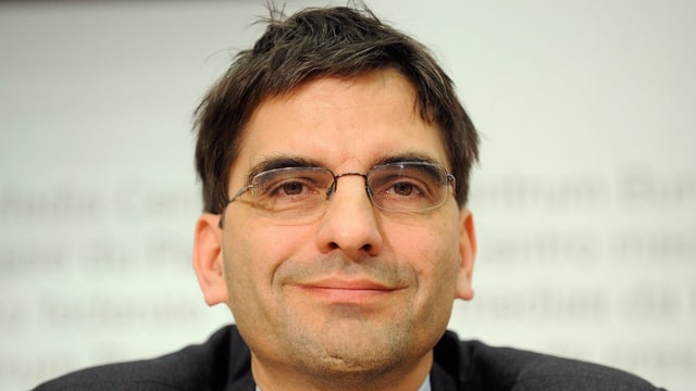 Aymo Brunetti lächelt anlässlich einer Konferenz in die Kamera. Aymo Brunetti lächelt anlässlich einer Konferenz in die Kamera.