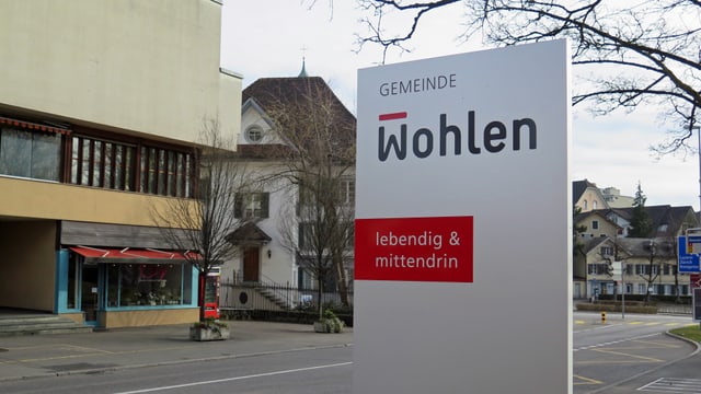 Schild vor dem Gemeindehaus, im Hintergrund Hauptstrasse und Dorf Schild vor dem Gemeindehaus, im Hintergrund Hauptstrasse und Dorf