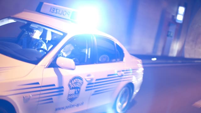 Ein Polizeiauto ist mit Blaulicht unterwegs Ein Polizeiauto ist mit Blaulicht unterwegs