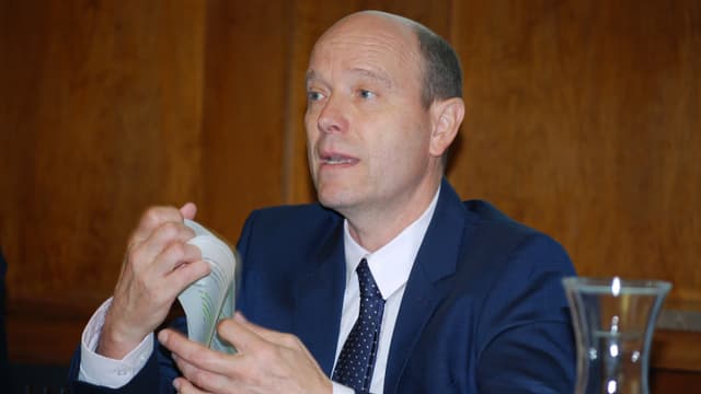 Mann referiert mit Papier in den Händen Mann referiert mit Papier in den Händen