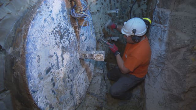 Arbeiter der Swisstopo hämmert den Endlagerkanister aus der Wand. Arbeiter der Swisstopo hämmert den Endlagerkanister aus der Wand.
