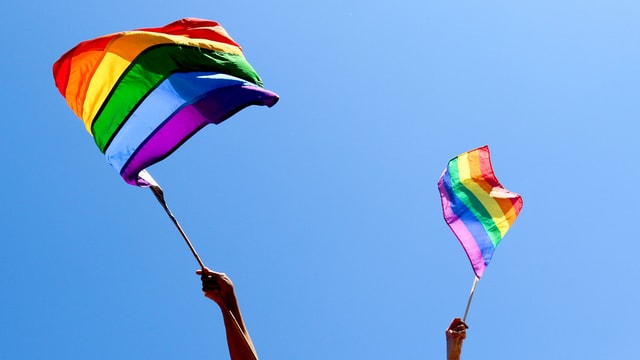 Zwei Hände schwingen Regenbogenfahne. Zwei Hände schwingen Regenbogenfahne.