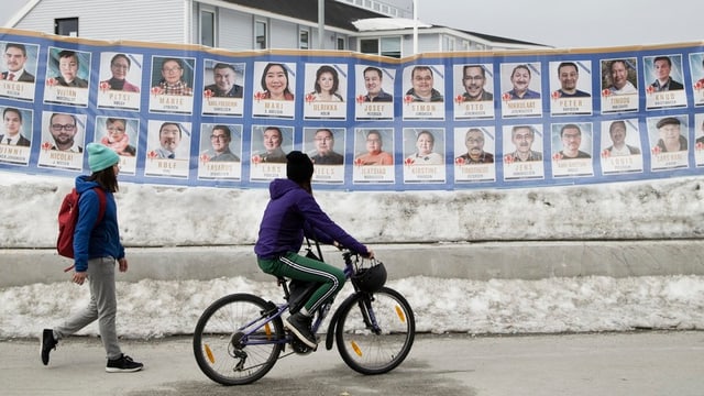 Zwei Personen gehen an Wahlplakaten vorbei Zwei Personen gehen an Wahlplakaten vorbei