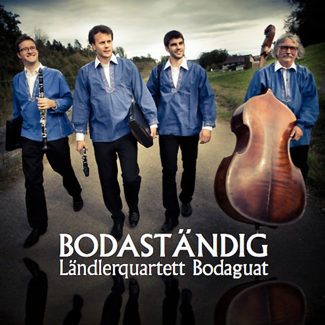 Andreas Ambühl und Mathias Landtwing mit Klarinette, Robin Mark mit Schwyzerörgeli und Ueli Mooser mit dem Kontrabass unterwegs auf einer Bergstrasse. Andreas Ambühl und Mathias Landtwing mit Klarinette, Robin Mark mit Schwyzerörgeli und Ueli Mooser mit dem Kontrabass unterwegs auf einer Bergstrasse.