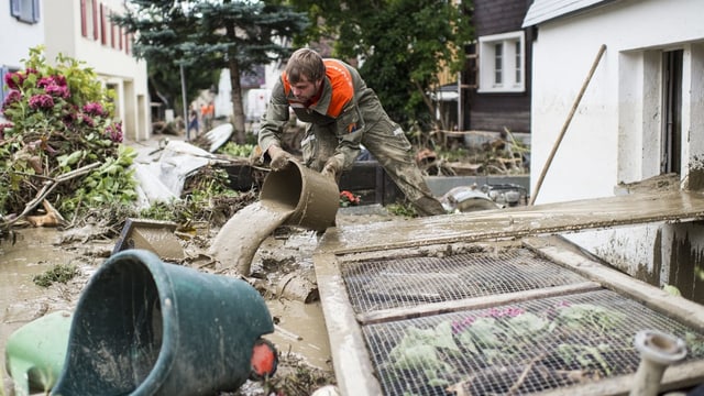 Mann leert Eimer mit Schlamm aus. Mann leert Eimer mit Schlamm aus.