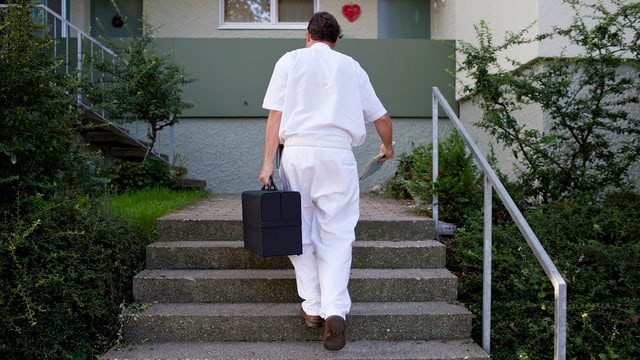 Arzt auf dem Weg in eine Wohnung. Arzt auf dem Weg in eine Wohnung.