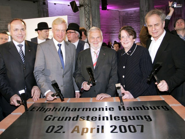 Fünf Personen mit Meissel hinter dem Grundstein der Elbphilharmonie. Fünf Personen mit Meissel hinter dem Grundstein der Elbphilharmonie.