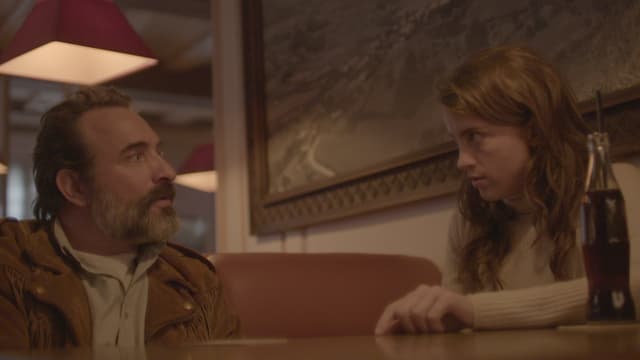 Ein Mann und eine Frau sitzen am Tisch und starren sich an. Ein Mann und eine Frau sitzen am Tisch und starren sich an.