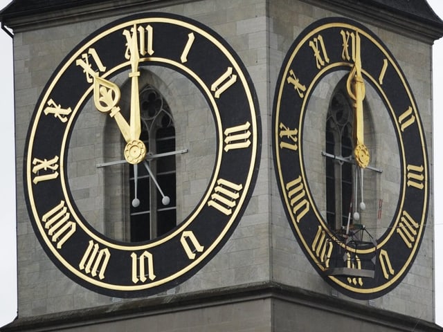 Die Uhr des St. Peters in Zürich mit den goldigen Zeigern und Ziffern.