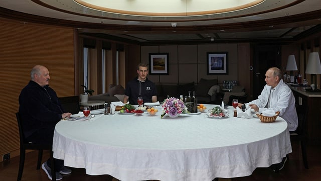 Lukaschenko, Nikolai und Putin an einem runden, weiss gedeckten Tisch. Lukaschenko, Nikolai und Putin an einem runden, weiss gedeckten Tisch.