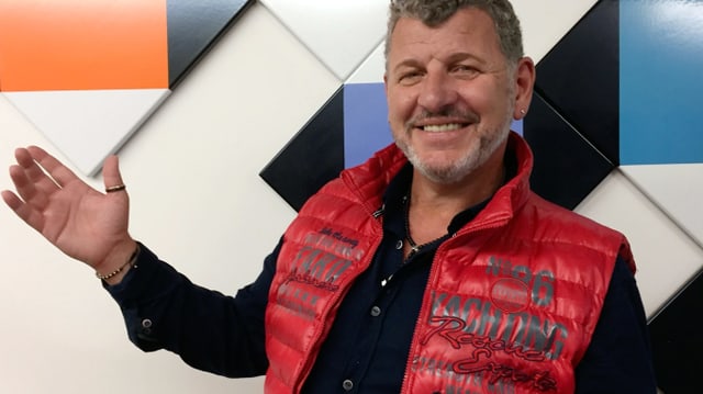 Ein Mann mit roter Weste über einem schwarzen Pullover. Ein Mann mit roter Weste über einem schwarzen Pullover.