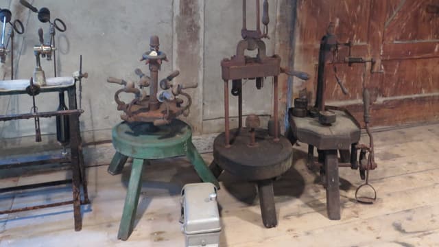 Vier alte Maschinen stehen auf einem Holzboden Vier alte Maschinen stehen auf einem Holzboden