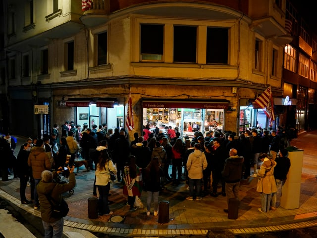 Fans von Athletic Bilbao schauen sich im Freien vor einer Bar den Final der spanischen Supercopa im saudi-arabischen Riad an.
