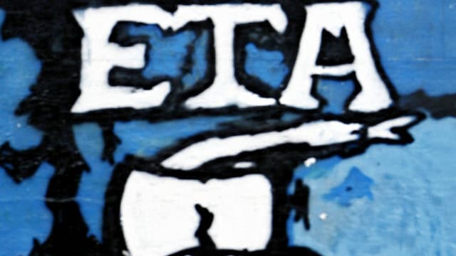 Graffiti mit dem weissen Schriftzug"ETA" und einem Beil auf einer blauen Wand. Graffiti mit dem weissen Schriftzug"ETA" und einem Beil auf einer blauen Wand.