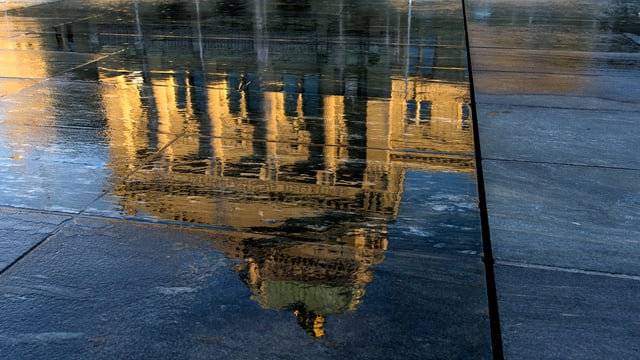 Spiegelung des Bundeshauses in einer Wasserlache. Spiegelung des Bundeshauses in einer Wasserlache.