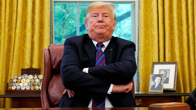 Auf dem Bild ist Donald Trump in einer verklemmten Haltung zu sehen. Auf dem Bild ist Donald Trump in einer verklemmten Haltung zu sehen.