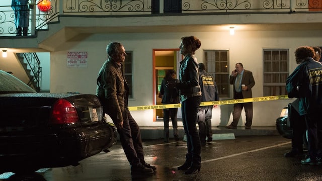 Titus Welliver als Harry Bosch und Amy Aquino als Grace Billets sehen einander an, Bosch an ein Auto gelehnt. Im Hintergrund ein schäbiges amerikanisches Motel, das mit Polizei-Absperrband als Tatort markiert ist. Titus Welliver als Harry Bosch und Amy Aquino als Grace Billets sehen einander an, Bosch an ein Auto gelehnt. Im Hintergrund ein schäbiges amerikanisches Motel, das mit Polizei-Absperrband als Tatort markiert ist.