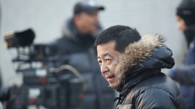 Jia Zhangke in der Daunenjacke mit Pelzkapuze bei Dreharbeiten. Jia Zhangke in der Daunenjacke mit Pelzkapuze bei Dreharbeiten.