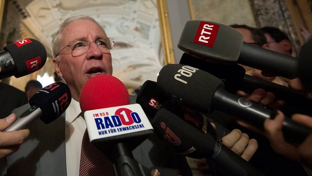 Blocher umringt von vielen Mikrofonen. Blocher umringt von vielen Mikrofonen.