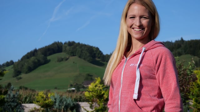 Eine Frau vor grünen Hügeln und blauem Himmel. Sie lacht. Eine Frau vor grünen Hügeln und blauem Himmel. Sie lacht.