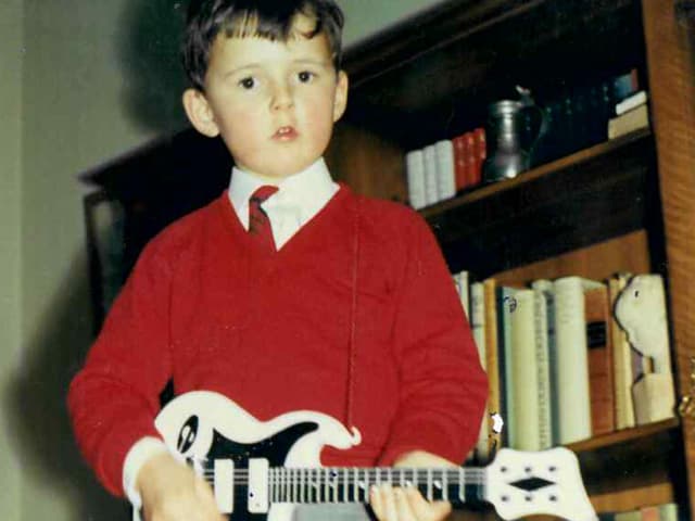 Kleiner Junge mit E-Gitarre.